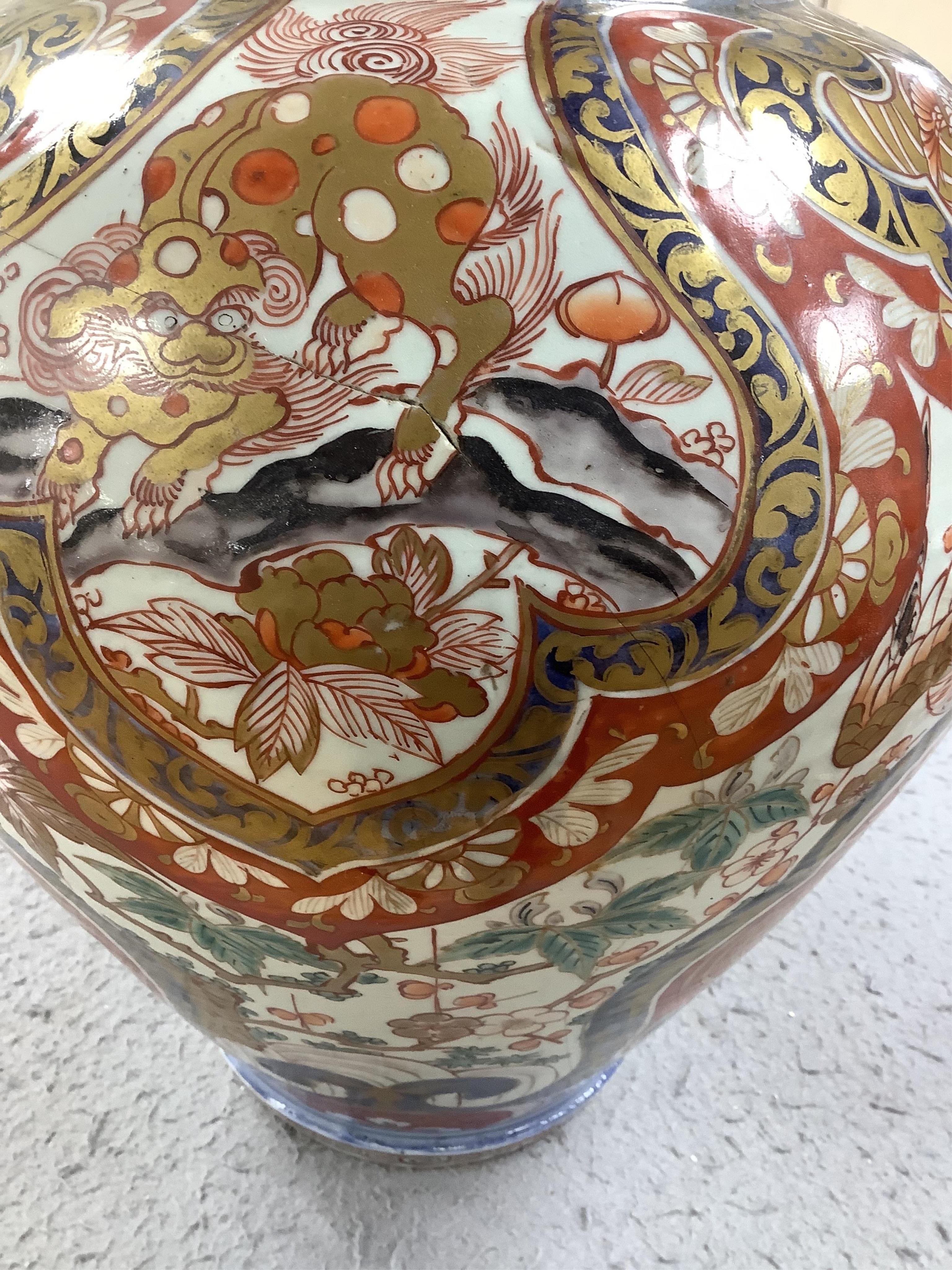 A large 19th century Imari vase with dragon finial to cover, 61cm high. Condition - badly cracked and restored